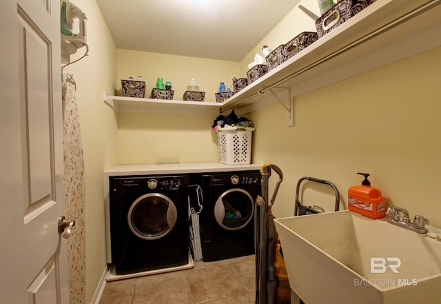 washroom with laundry area, a sink, washer and clothes dryer, and light tile patterned floors