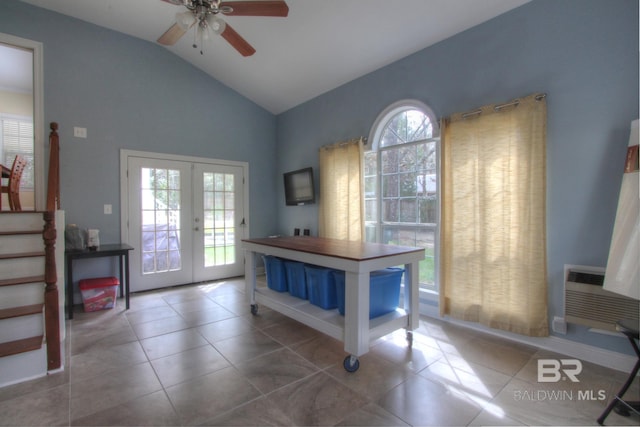 entrance foyer featuring a wall unit AC, ceiling fan, tile patterned floors, vaulted ceiling, and french doors