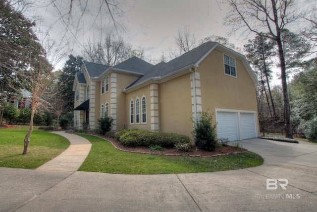 view of side of home with an attached garage, a lawn, concrete driveway, and stucco siding