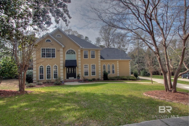 view of front of home featuring stucco siding and a front yard