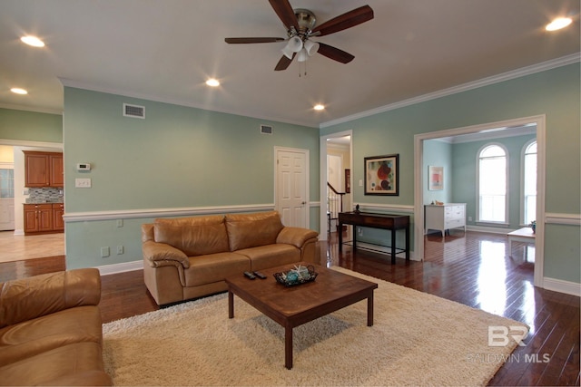 living room featuring baseboards, visible vents, and wood finished floors