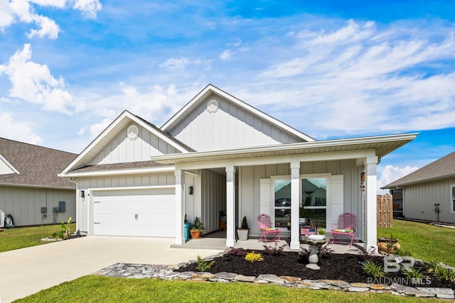 4142 Montague Dr, Gulf Shores, AL 36542 - view of front facade with board and batten siding, covered porch, concrete driveway, and an attached garage