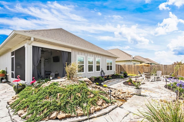 4142 Montague Dr, Gulf Shores, AL 36542 - back of property with a patio, a fenced backyard, a sunroom, and board and batten siding