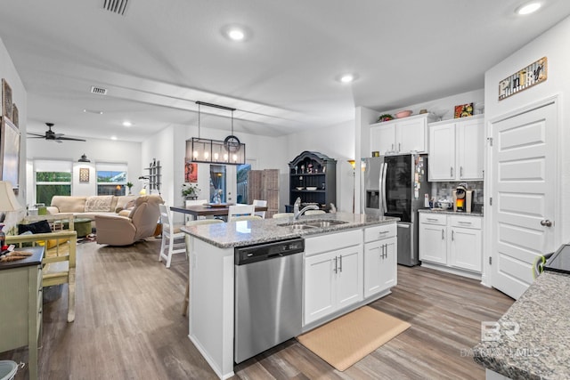 4142 Montague Dr, Gulf Shores, AL 36542 - kitchen with a sink, stainless steel appliances, wood finished floors, white cabinetry, and recessed lighting