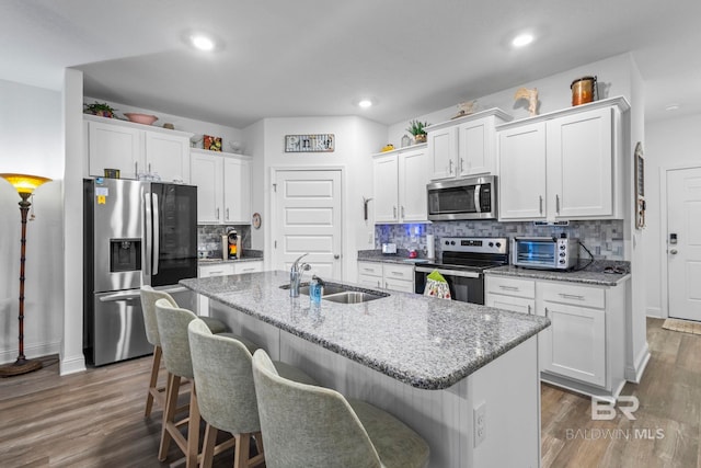 4142 Montague Dr, Gulf Shores, AL 36542 - kitchen featuring stainless steel appliances, a sink, dark wood-style floors, a breakfast bar area, and white cabinetry