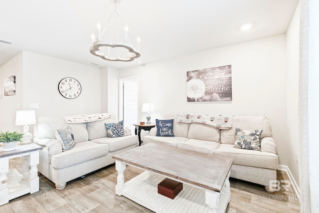 living room featuring light hardwood / wood-style floors and a notable chandelier