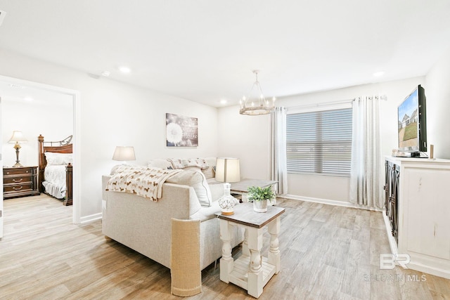 living room featuring a chandelier and light hardwood / wood-style floors