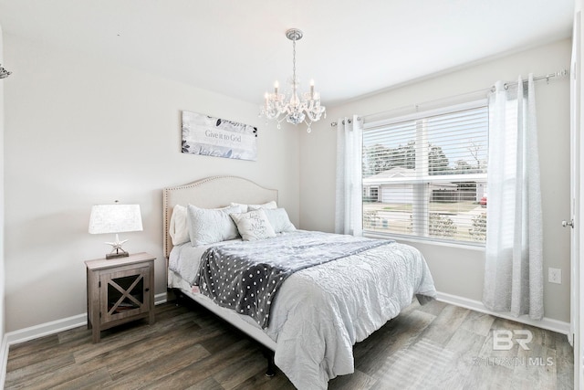 bedroom with dark hardwood / wood-style flooring and a chandelier