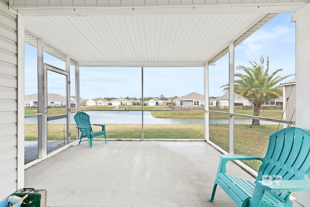 unfurnished sunroom featuring a water view