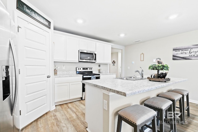 kitchen featuring a center island with sink, white cabinets, sink, and stainless steel appliances