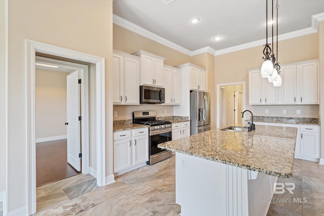 kitchen with appliances with stainless steel finishes, white cabinetry, and a kitchen island with sink