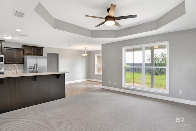 16529 Cold Mill Loop, Foley, AL 36535 - kitchen featuring stainless steel fridge, light carpet, a kitchen breakfast bar, light countertops, and dark brown cabinetry