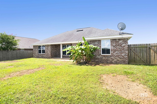 16529 Cold Mill Loop, Foley, AL 36535 - rear view of house with brick siding, a fenced backyard, and roof with shingles