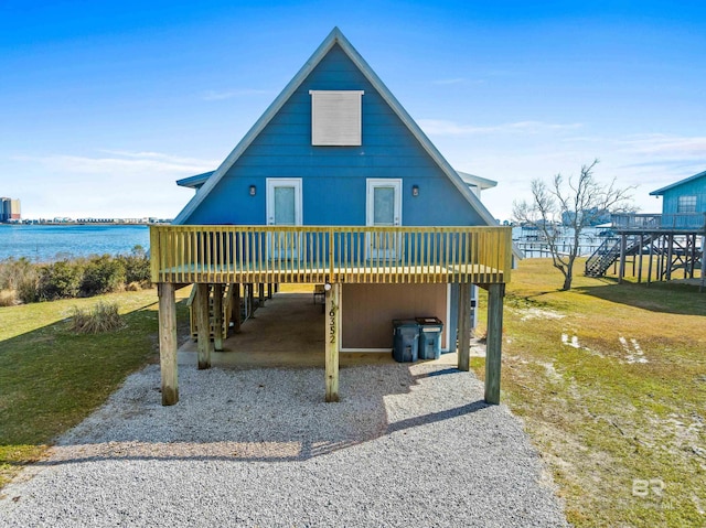 16352 Brigadoon Trl, Gulf Shores, AL 36542 - rear view of house with a deck with water view, a carport, and a lawn