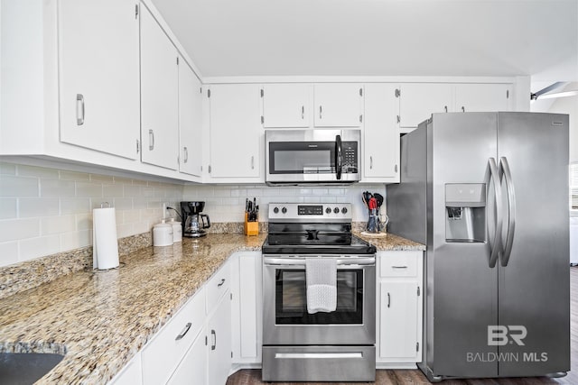 kitchen featuring backsplash, appliances with stainless steel finishes, and white cabinets