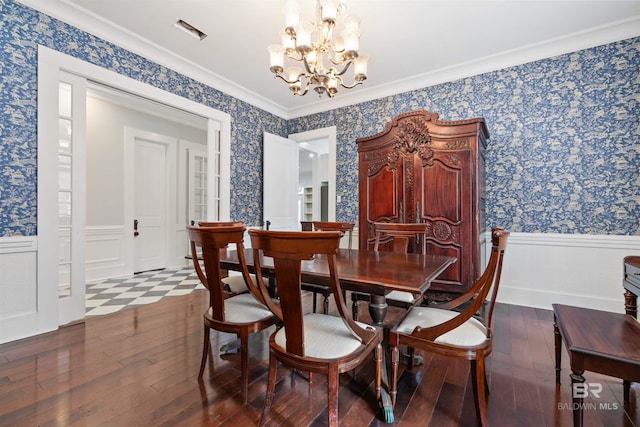 dining room with hardwood / wood-style floors, a notable chandelier, and crown molding