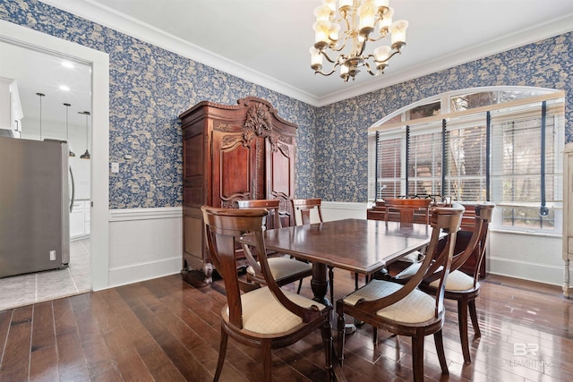 dining space featuring crown molding, wood-type flooring, and a notable chandelier