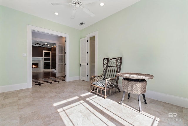 sitting room featuring ceiling fan and light tile patterned floors