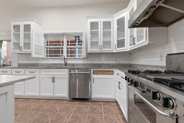 kitchen with sink, extractor fan, decorative backsplash, white cabinets, and appliances with stainless steel finishes