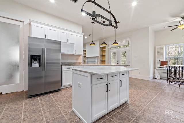 kitchen with light stone countertops, ceiling fan, decorative light fixtures, white cabinets, and stainless steel fridge with ice dispenser