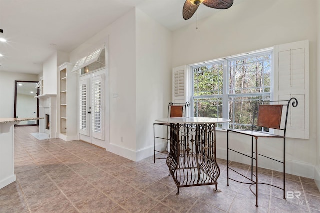 office with plenty of natural light, ceiling fan, and built in shelves