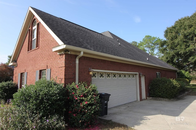 306 S Tee Dr, Fairhope, AL 36532 - view of side of property featuring roof with shingles, concrete driveway, brick siding, and an attached garage