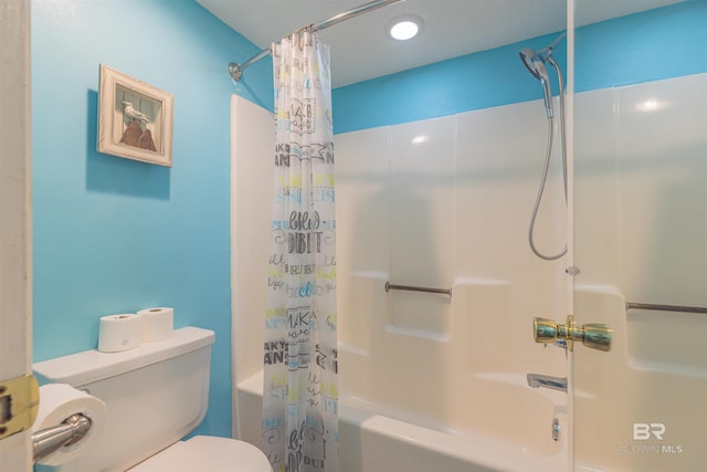 bathroom featuring shower / bath combo with shower curtain and toilet