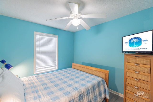 bedroom with hardwood / wood-style flooring, a textured ceiling, and ceiling fan