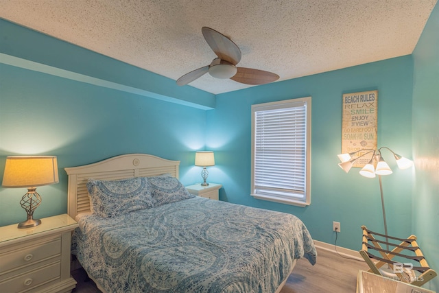 bedroom with light hardwood / wood-style floors, a textured ceiling, and ceiling fan