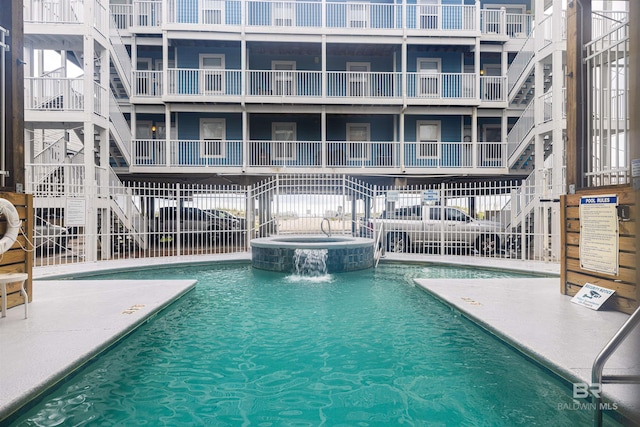 view of pool featuring a community hot tub and pool water feature