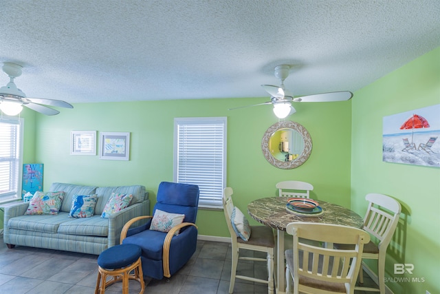 tiled living room with ceiling fan and a textured ceiling