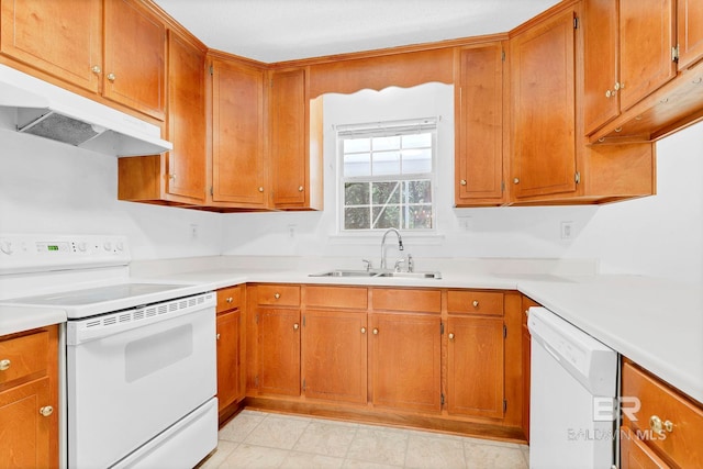 kitchen featuring a sink, brown cabinetry, white appliances, under cabinet range hood, and light countertops