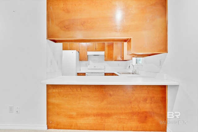 kitchen featuring freestanding refrigerator, under cabinet range hood, a sink, a peninsula, and electric stove