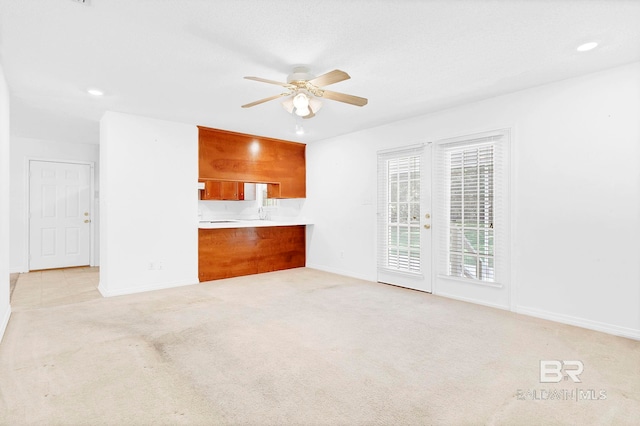 unfurnished living room with baseboards, recessed lighting, ceiling fan, and light colored carpet