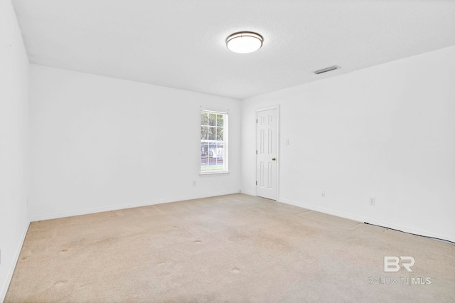 spare room with visible vents, baseboards, and carpet floors