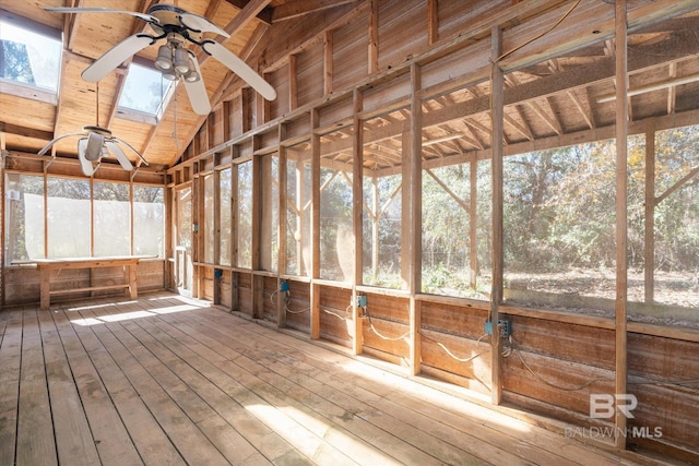 unfurnished sunroom with ceiling fan and vaulted ceiling with skylight