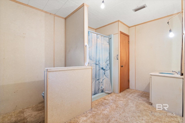 bathroom featuring ornamental molding, sink, and curtained shower