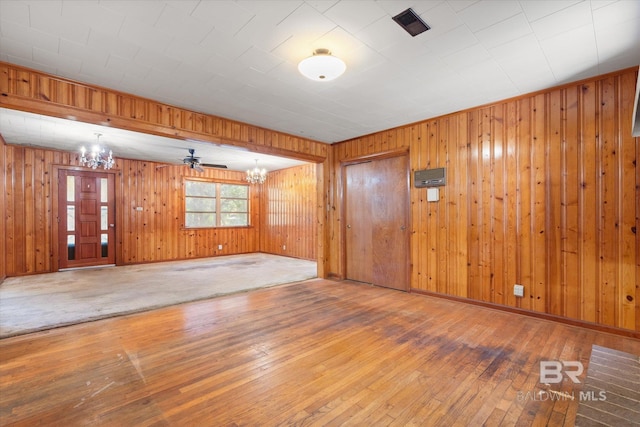 spare room featuring wood-type flooring and a chandelier