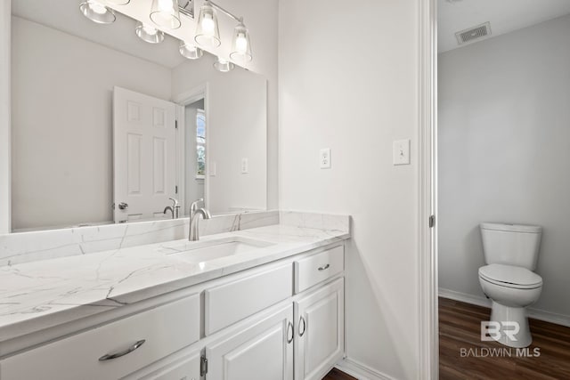 bathroom featuring hardwood / wood-style flooring, vanity, and toilet