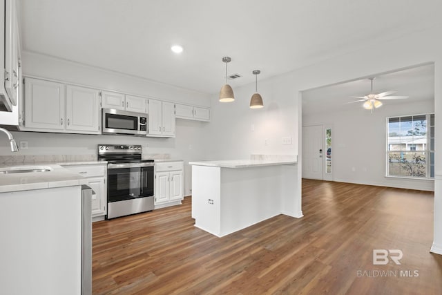 kitchen featuring white cabinetry, sink, decorative light fixtures, and stainless steel appliances