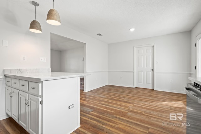 kitchen with white cabinetry, wood-type flooring, a textured ceiling, kitchen peninsula, and pendant lighting