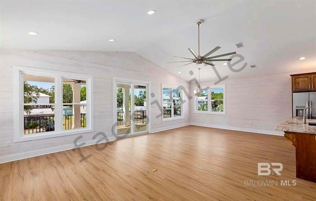 unfurnished living room with light hardwood / wood-style floors, ceiling fan, and lofted ceiling