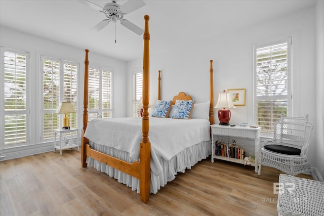 bedroom with multiple windows, ceiling fan, and light wood-type flooring