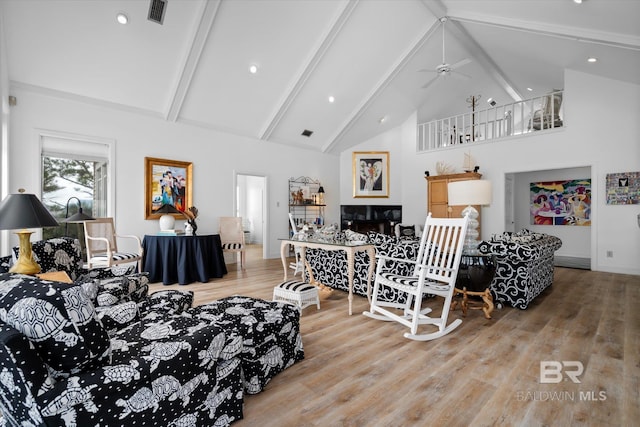 living room with beam ceiling, high vaulted ceiling, hardwood / wood-style floors, and ceiling fan