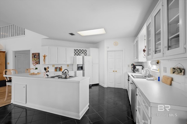 kitchen with white cabinetry, white refrigerator with ice dispenser, sink, and kitchen peninsula