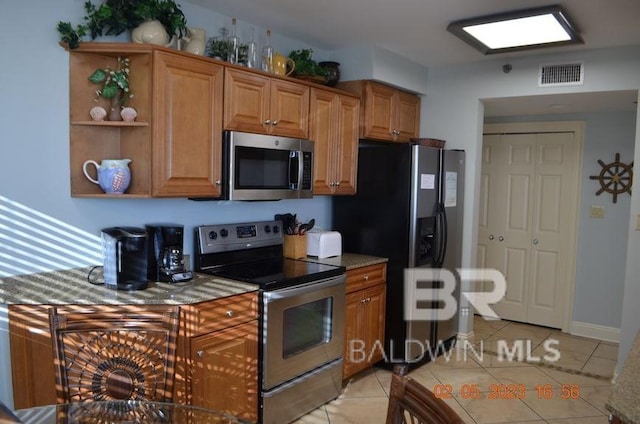 kitchen with light tile patterned floors and stainless steel appliances