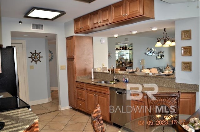 kitchen with an inviting chandelier, sink, light stone countertops, appliances with stainless steel finishes, and light tile patterned flooring