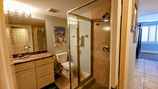 bathroom with tile patterned floors, vanity, toilet, and an enclosed shower