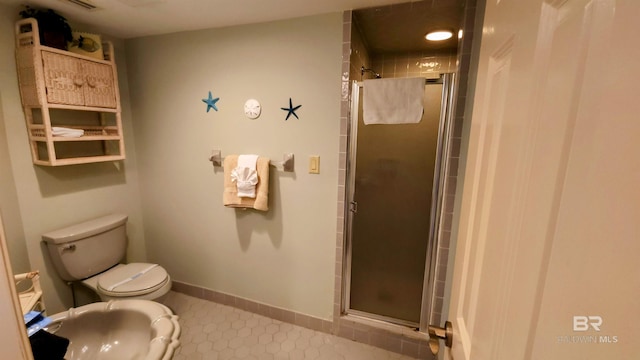 bathroom featuring toilet and a shower with door