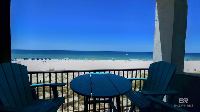 balcony featuring a water view and a beach view